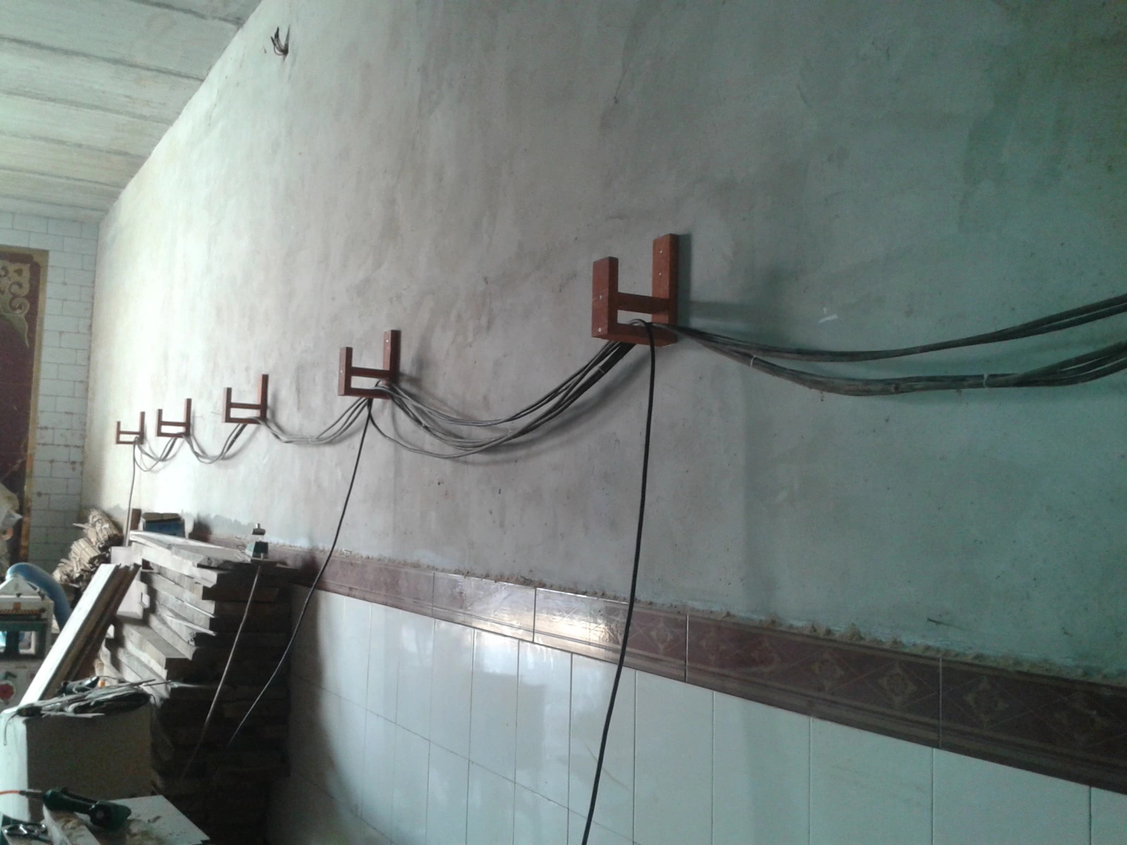 Close view of handmade wall brackets carrying workshop cables
